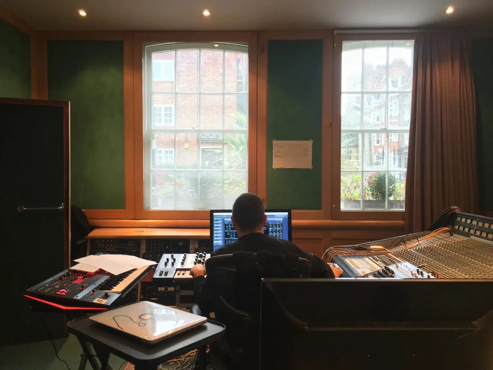 An engineer working at a mixing console in a recording studio